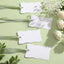 Tarjetas irregulares con borde ondulado para mesa de boda en blanco con cinta de satén