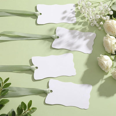 Tarjetas irregulares con borde ondulado para mesa de boda en blanco con cinta de satén