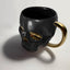 Taza grande de cerámica con diseño de calavera negra y ribete dorado