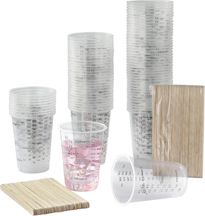 Tazas de mezcla de pintura con varillas de madera y vasos medidores transparentes
